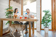 © rh2010 - Young couple having a breakfast sitting at the table with their dog in the wooden country house