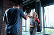 Box lesson. Blonde-haired athletic female boxer having nice abs having box lesson with famous boxer