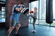 White sneakers. Beautiful athletic woman wearing white sneakers feeling extremely happy while boxing with trainer