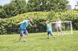 © Louis-Photo - Man with child playing football outside on field