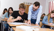 © JackF - Young boy is writing test and teacher is explaining about questions