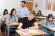 © JackF - Young boy is writing test and thinking about questions at the desk