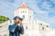 man traveler with bag cross body and hat and take a photo at “Phra Sumen Fort” background from Bangkok Thailand. Traveling Thailand.