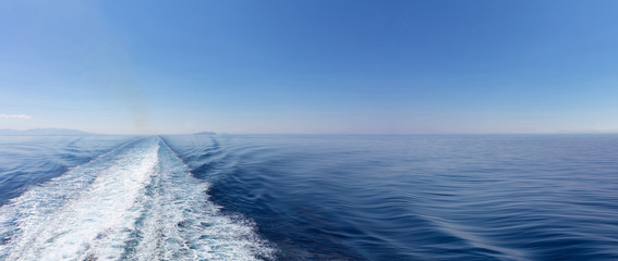 Mediterranean sea. Boat white wake, on blue sea and sky background, view from the ship. Copy space, banner