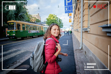 Beautiful happy young woman girl tourist hiker walks the streets in Helsinki, Finland, travel to Northern Europe, with backpack and camera