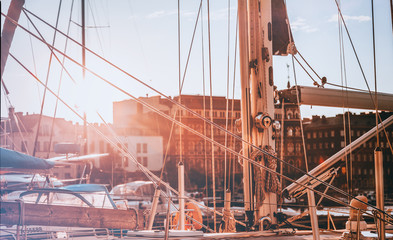 Wall Mural - Cordage, ropes and other details of the boat yacht on a city background in the setting sun, the beautiful journey atmospheric background and texture