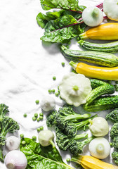 Fresh organic vegetables - zucchini, squash, cucumbers, broccoli, onions, garlic, chard, green peas on a light background, top view. Healthy lifestyle diet vegetarian food concept. Flat lay