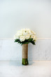 A white cream roses bouquet on the white wall - side view