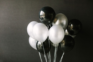 black and white balloons on a dark black background. celebration concept / white and black balloons 