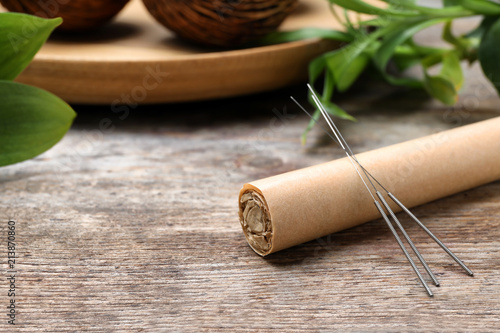 Fotografie, Obraz Moxa stick with needles for acupuncture on wooden table