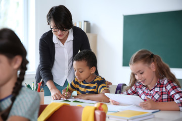 Poster - Female teacher helping child with assignment at school