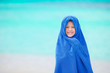 © travnikovstudio - Adorable little girl wrapped in towel at tropical beach after swimming in the sea