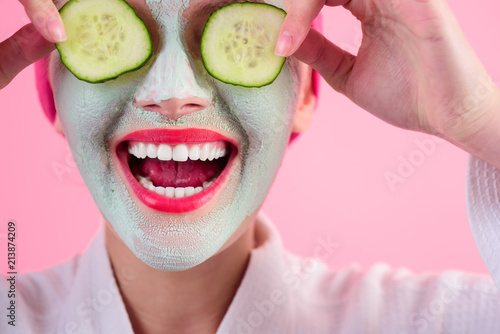 Fotografie, Obraz Close up portrait of woman with facial cosmetical mask and cucumber slice on eyes