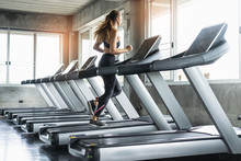 Cute Young Woman Exercising On  Treadmill At A Gym.Active Young Woman Running On Treadmill. Smile And Funny Emotion.