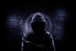 © releon8211 - Internet crime concept. Hacker working on a code on dark digital background with digital interface around.