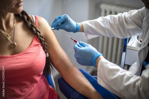 Fotografia medico disinfetta la pelle di una paziente prima di fare una vaccinazione