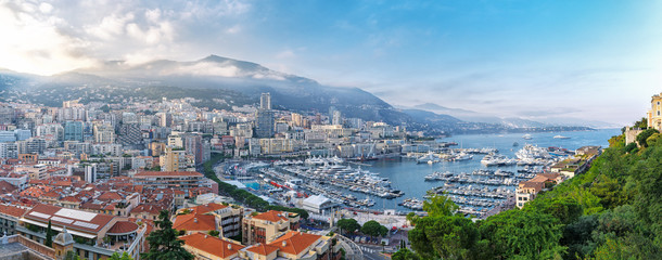 Principality of Monaco. Beautiful panoramic view on Monaco, golden hour scenery. View on apartment building, casino, great port with luxury yachts. Monaco is popular travel destination, wealth symbol.