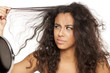 portrait of a unhappy young dark-skinned woman with messy long hair on a white background