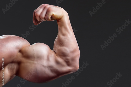 Fotografía bodybuilding naked male arm with biceps on grey background