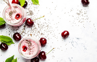 Wall Mural - Pink cherry smoothies with yoghurt and chia seeds, gray background, top view