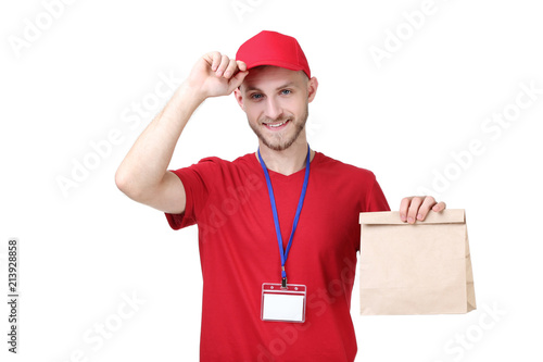 Fotografie, Obraz Delivery man in red uniform with paper bag on white background