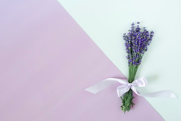 Flowers background. a beautiful bouquet of lavender flowers on geometric paper of two colors of mint and lavender. top view. copy space