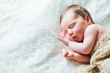 © kaloriya - Newborn baby sleeping on white sheets