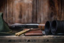 Professional Hunters Equipment For Hunting. Detail On The Ammunition.  Wooden Black Background With Rifle, Hat, And Other Equipment For Hunting. 