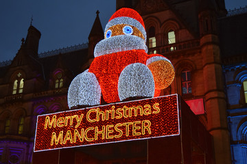 Santa sitting on a building in the city of manchester 