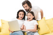 © LIGHTFIELD STUDIOS - emotional family using laptop together on yellow sofa isolated on white