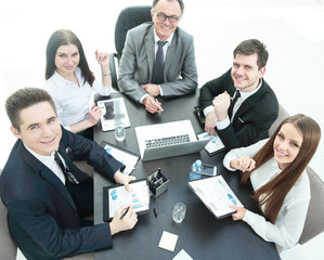 business team sitting at Desk and looking at camera.