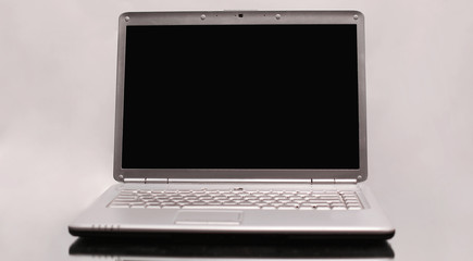 Laptop with blank screen on grey background