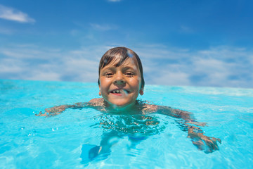 Canvas Print - Laughing boy swimming in outdoor pool at sunny day