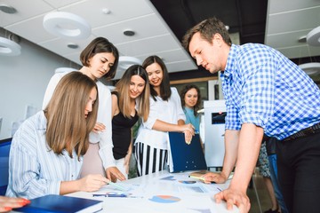 Wall Mural - Business team in casual clothes brainstorming at the table in a modern office