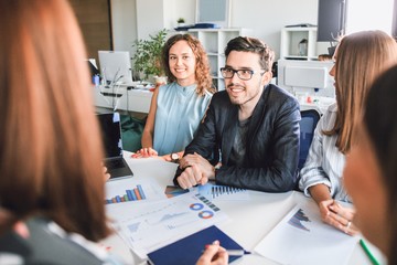 Modern business people talk and smile during a conference in the office