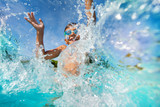 Fototapeta  - Happy boy playing and splashing in swimming pool