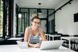 © bnenin - Young woman sitting at table surfing internet for notes for her study.