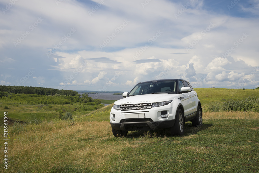 Car Land Rover Range Rover is standing at green grass at summer day near the city of Chistopol, Tatarstan, Russia. 8 July 2018. - obrazy, fototapety, plakaty 
