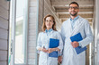 © LIGHTFIELD STUDIOS - two veterinarians in white coats walking with clipboards in veterinary clinic