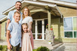© LIGHTFIELD STUDIOS - smiling parents and children standing in front of house