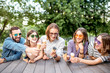© rh2010 - Young friends having fun with ice cream sitting together outdoors in the park
