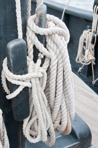 Fotografie, Obraz Detail of a halyard coiled neatly and secured on a cleat on the authentic replica of the Nina, one of Columbus's sailing ship