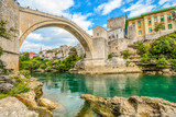 Fototapeta  - The emerald green waters of the river Neretva flow under the Mostar Bridge in the ancient city of Mostar, Bosnia and Herzegovina