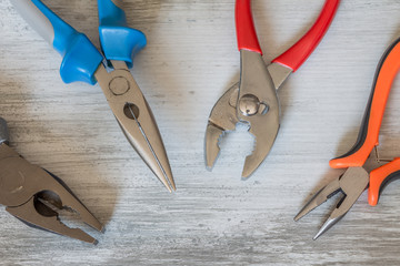 Blue/red/orange pliers. Grey background