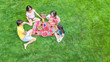 © Iuliia Sokolovska - Happy family having picnic in park, parents with kids sitting on grass and eating healthy meals outdoors, aerial view from above