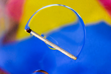  match in a colorful background of water and oil drops