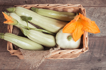 Wall Mural - Fresh green zucchini in the basket on rustic wooden table background. The concept of healthy eating, baby food, veganism, vegetarianism, raw food. Overhead top view, flat lay. Copy space.