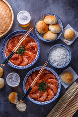 Wall Mural - Spicy asian shrimps in tomato sauce with rice, buns and beer, top view