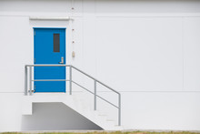Blue Steel Door With Grey Metal Handrail Factory Door And Fire Exit Stair.