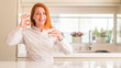 © Krakenimages.com - Thirsty redhead woman and glass of water doing ok sign with fingers, excellent symbol